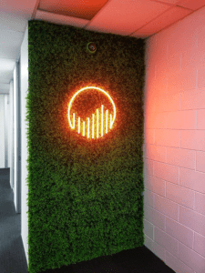 Next Generation neon logo illuminated signage against a plant wall by SIgnwise AUckland