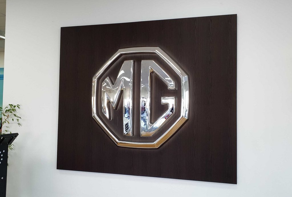 Interior Signage​ - Metalic Signage MG Logo o nwooden background - Signwise Auckland